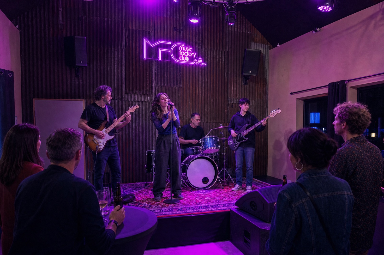 Jeune chanteuse au micro pendant une jam session au Music Factory Club, ado à la basse