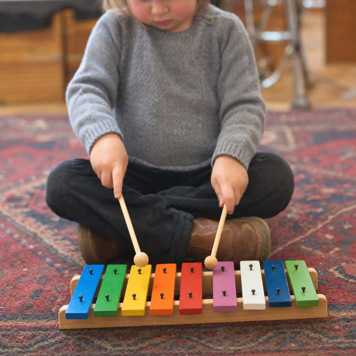 Les mains d'un tout-petit sur un xylophone coloré pendant l'éveil musical